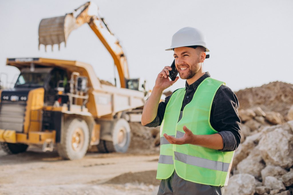 male worker with bulldozer in sand quarry